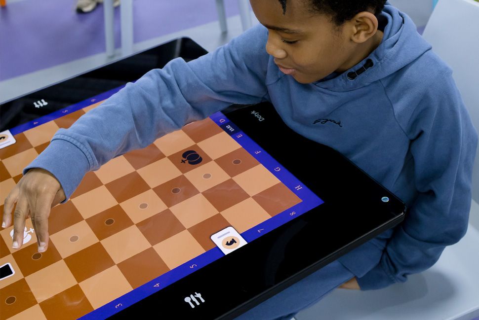 Child playing chess on a smart table